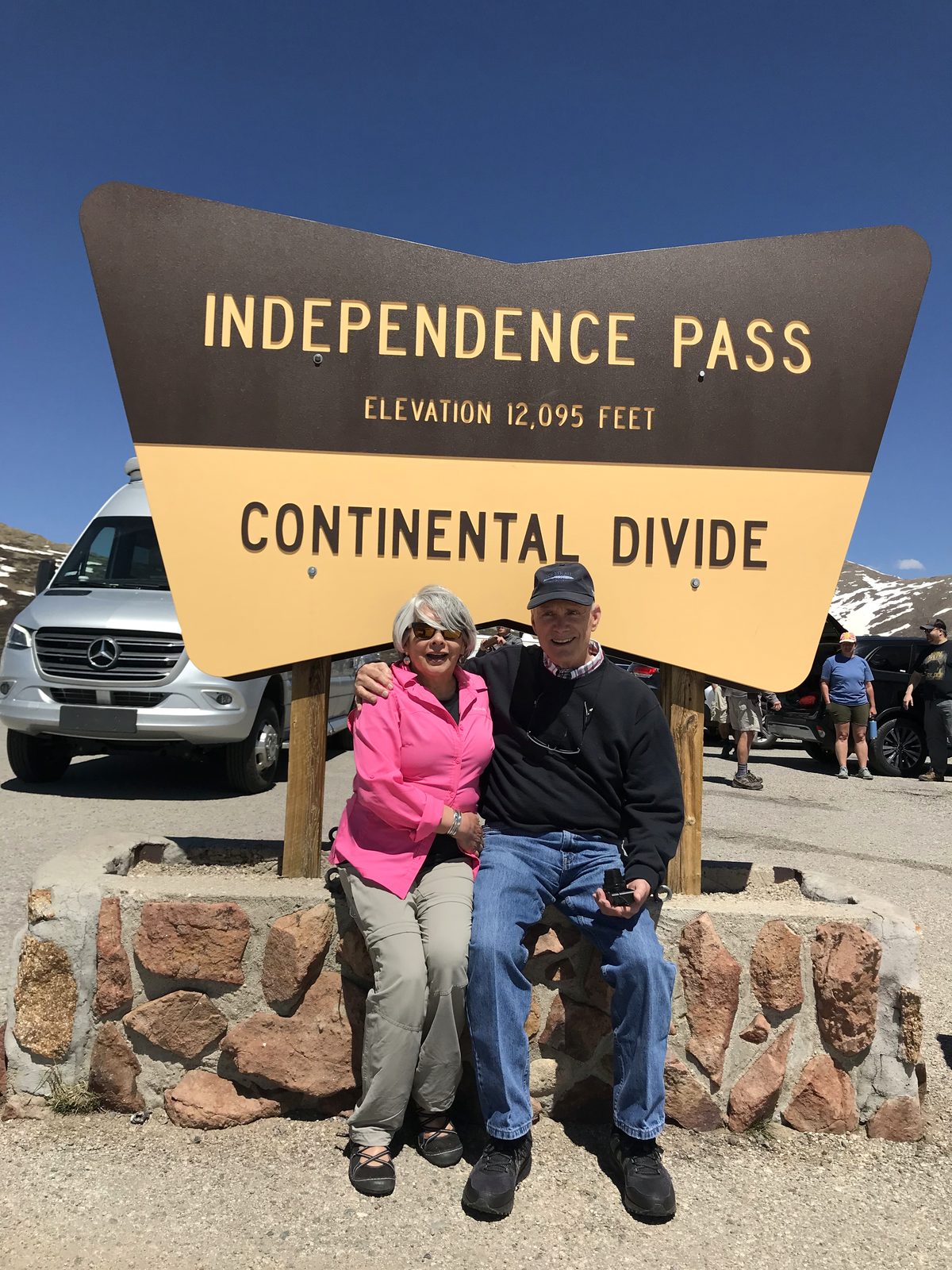 Sydnnia Wulff and her husband seated at the Independence Pass Continental Divide sign, elevation 12,095 feet