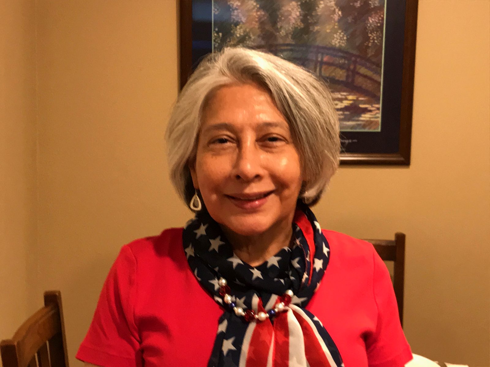 Sydnnia Wulff, smiling, wearing a red top and an American flag scarf